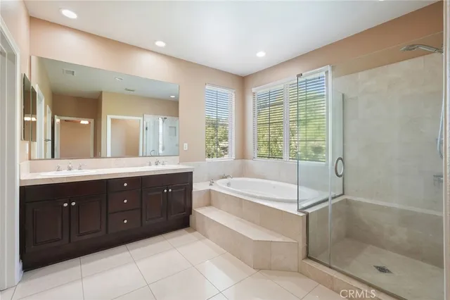 a spacious bathroom with a tub sink shower and mirror