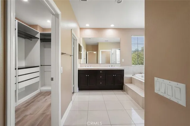 a spacious bathroom with a granite countertop sink mirror and a bathtub