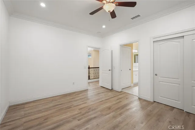 wooden floor in an empty room with a ceiling fan