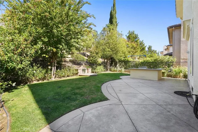a view of a yard with plants and a fountain