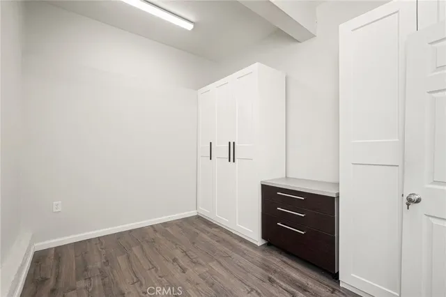 a view of walk in closet with wooden floor