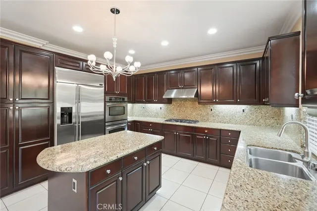 a kitchen with stainless steel appliances granite countertop a sink refrigerator and cabinets