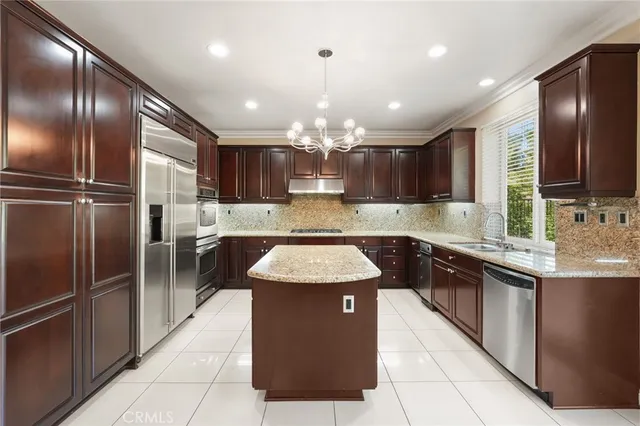 a kitchen with kitchen island granite countertop stainless steel appliances lots of counter top space cabinets and a sink
