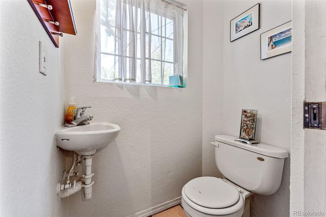 a bathroom with a toilet a sink and a window