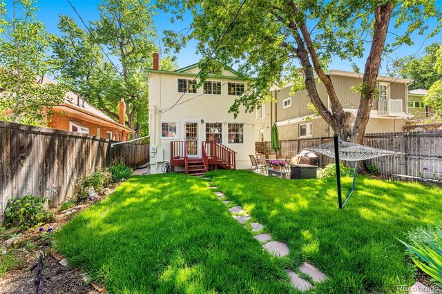 a view of a house with a backyard and a tree