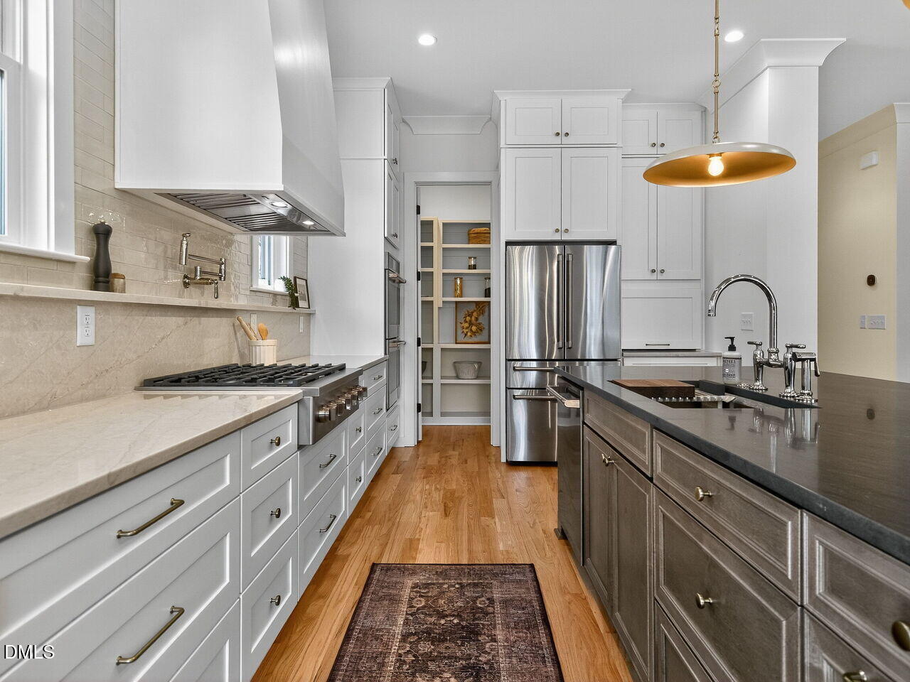 208 East Whitaker Mill Road Raleigh, NC 27608 - Photo 19 of 52 a kitchen with stainless steel appliances granite countertop a sink and a refrigerator