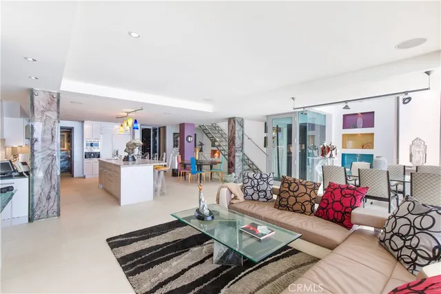 a living room with furniture and a dining table with kitchen view
