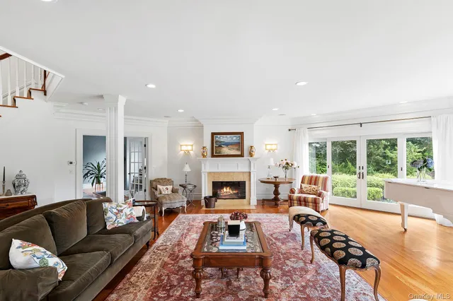 a living room with furniture fireplace and a large window