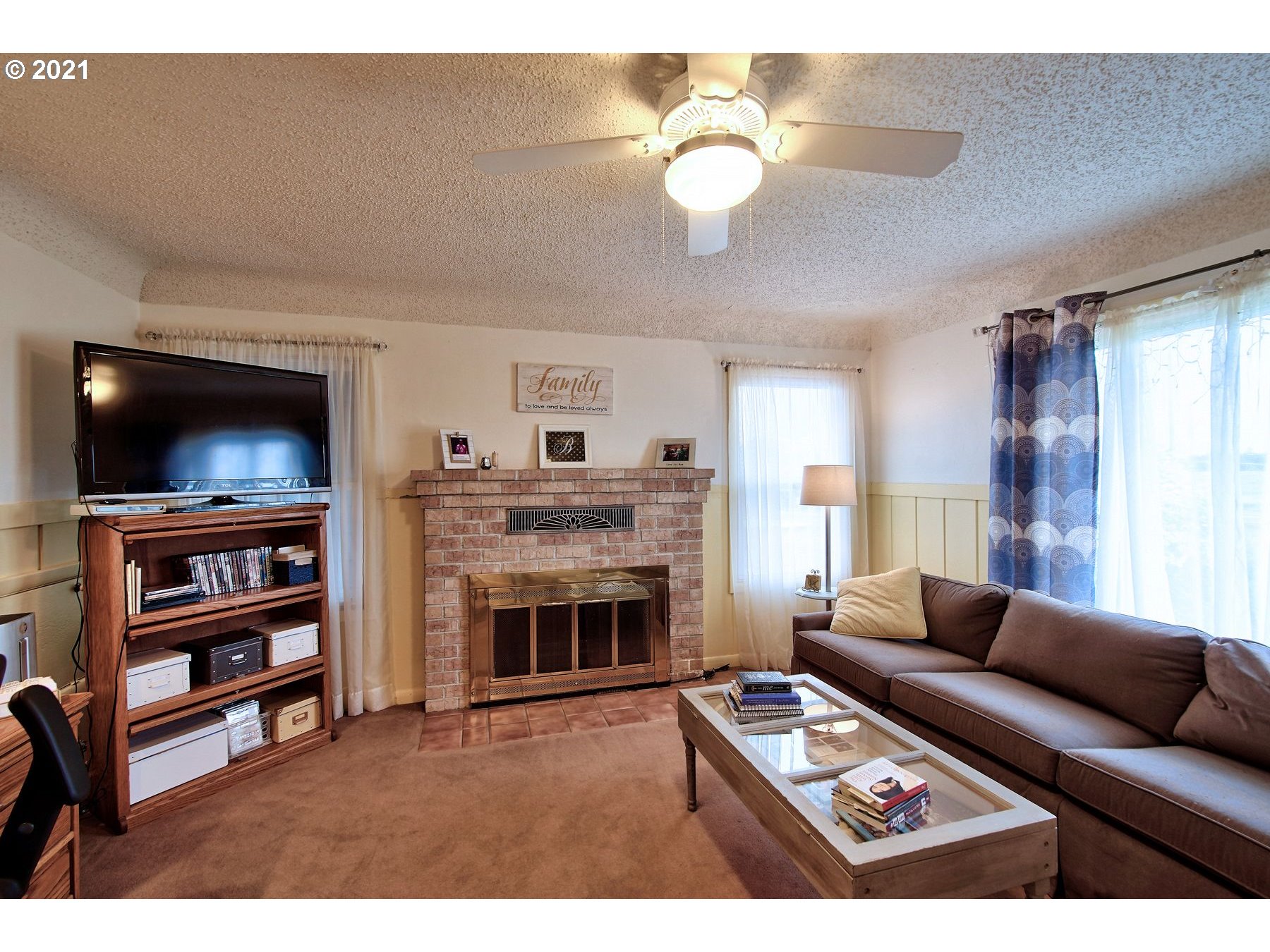 21451 River Road Northeast St. Paul, OR 97137 - Photo 12 of 32 a living room with furniture a flat screen tv and a fireplace