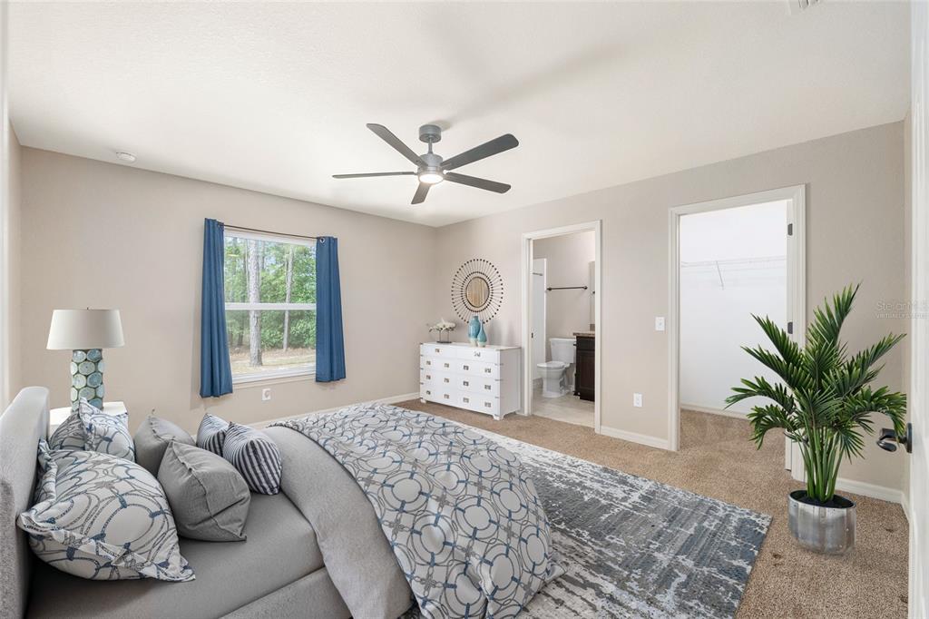 2 Hemlock Loop Drive Ocala, FL 34472 - Photo 15 of 28 a bedroom with a large bed and a chandelier