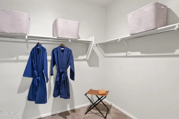 a view of walk in closet with clothes and shoes