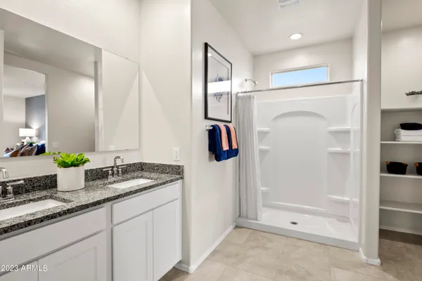 a bathroom with a granite countertop sink a mirror and shower