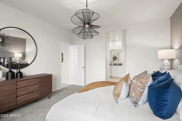 a bedroom with a large bed and a chandelier