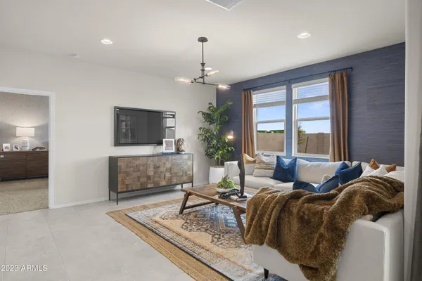a living room with furniture large window and a chandelier