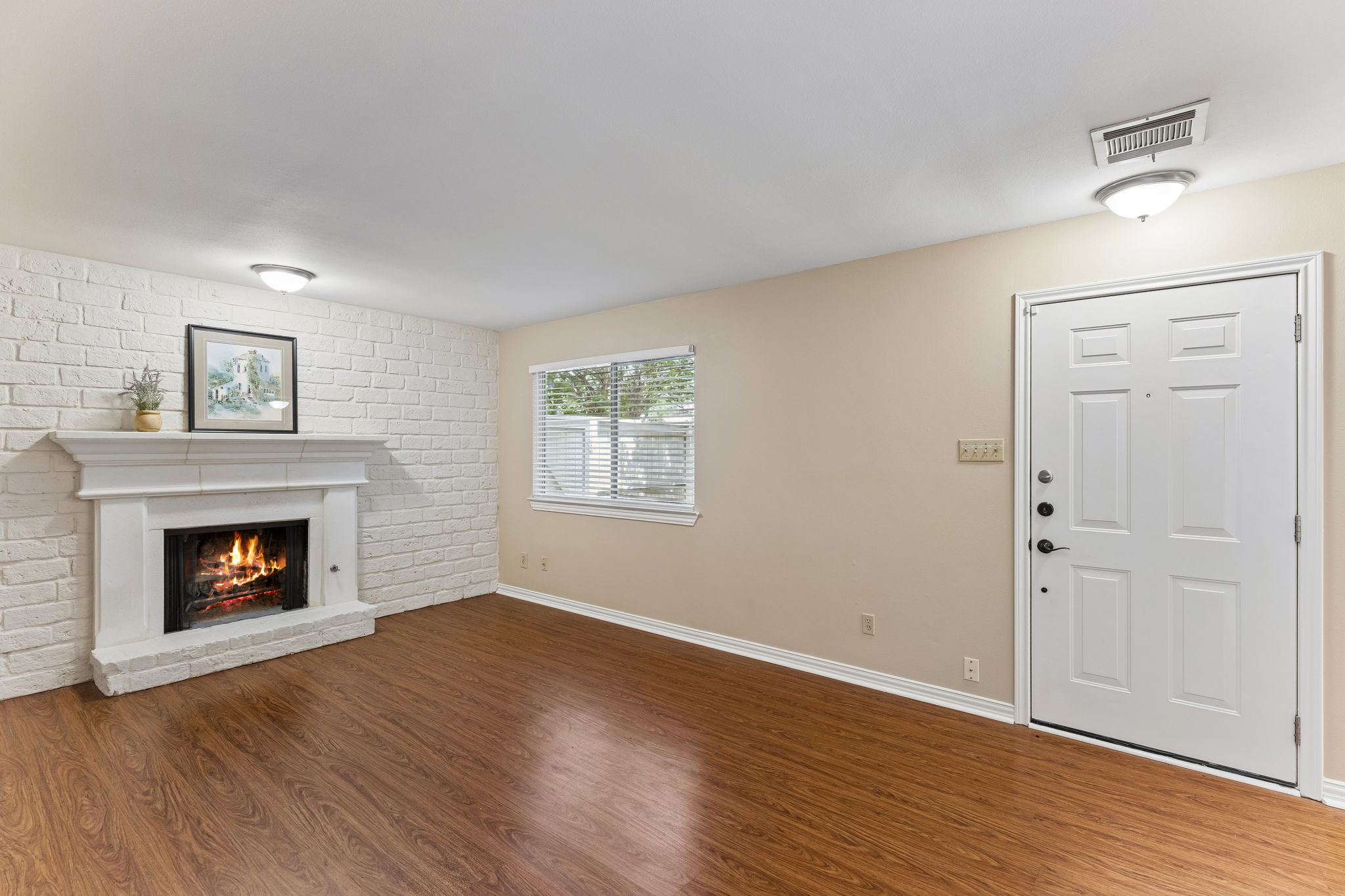 8340 Fathom Circle, Unit 103 Austin, TX 78750 - Photo 5 of 30 an empty room with wooden floor a fireplace and windows