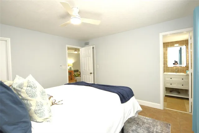 a bedroom with a large bed and a chandelier