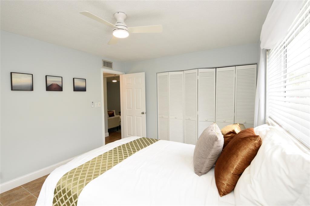 1010 Southeast 15th Street, Unit 112 Fort Lauderdale, FL 33316 - Photo 16 of 21 a bedroom with a bed and a chandelier