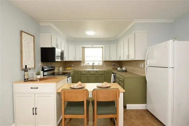a kitchen with a refrigerator a stove a microwave and cabinets