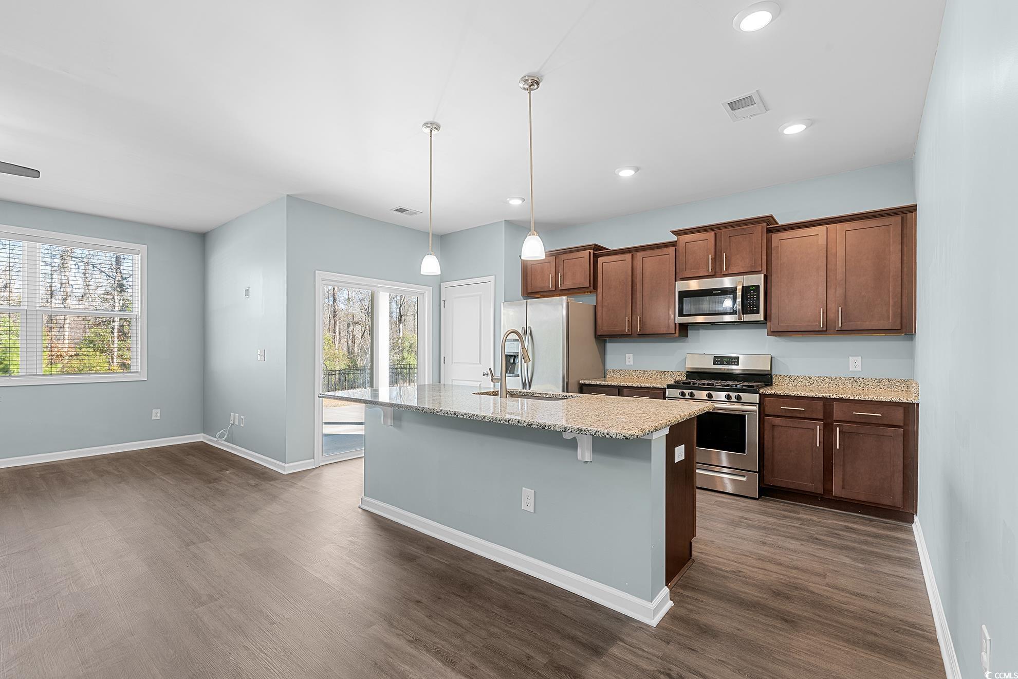 292 Carmello Circle Conway, SC 29526 - Photo 12 of 33 Kitchen with appliances with stainless steel finishes, light stone counters, a kitchen breakfast bar, decorative light fixtures, and an island with sink