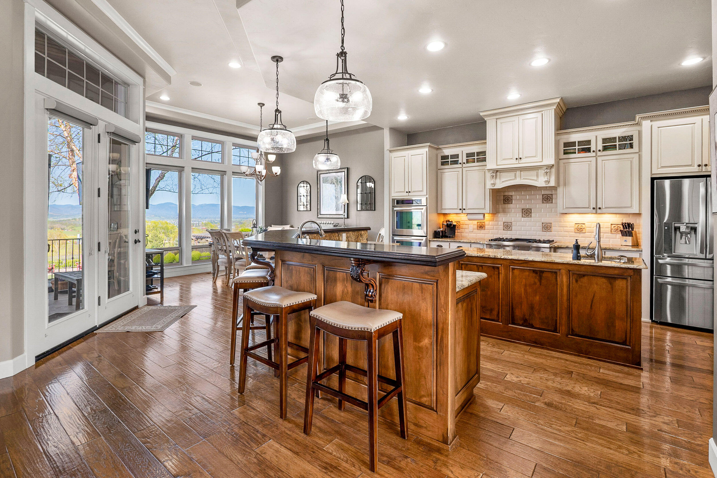 5709 Hughes Road Medford, OR 97504 - Photo 15 of 70 a kitchen with stainless steel appliances a dining table chairs stove and a refrigerator
