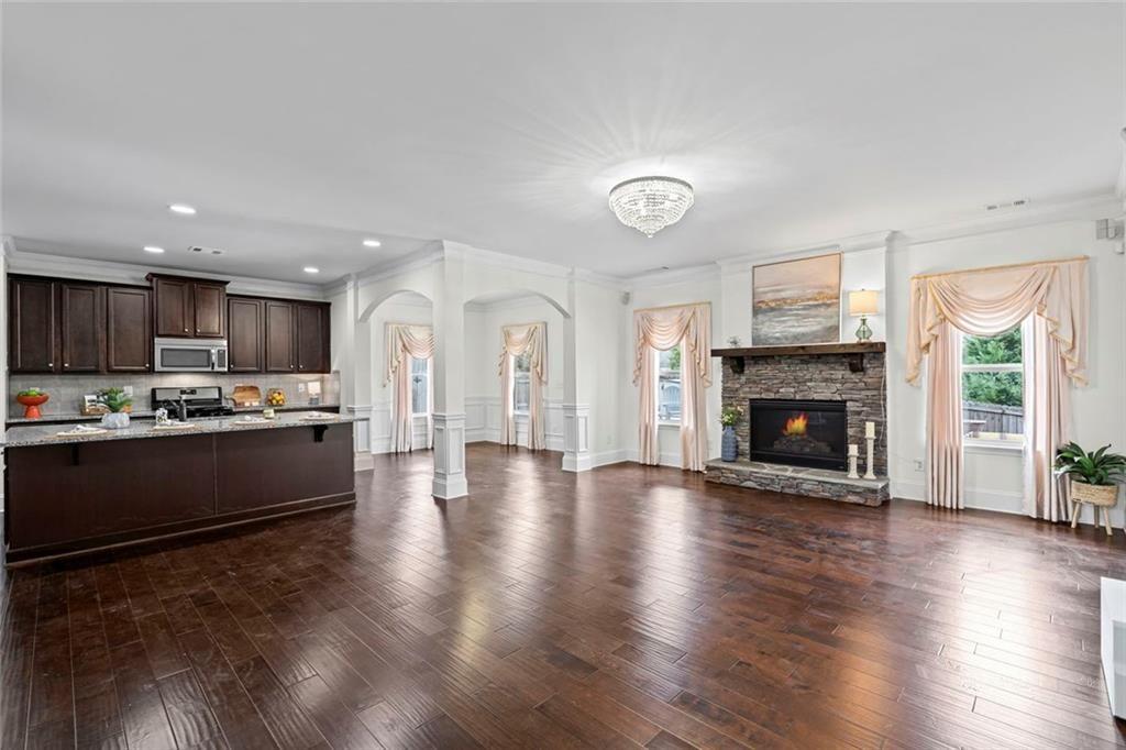 3915 Estates Path Cumming, GA 30040 - Photo 11 of 50 a large kitchen with hardwood floor a fireplace and windows