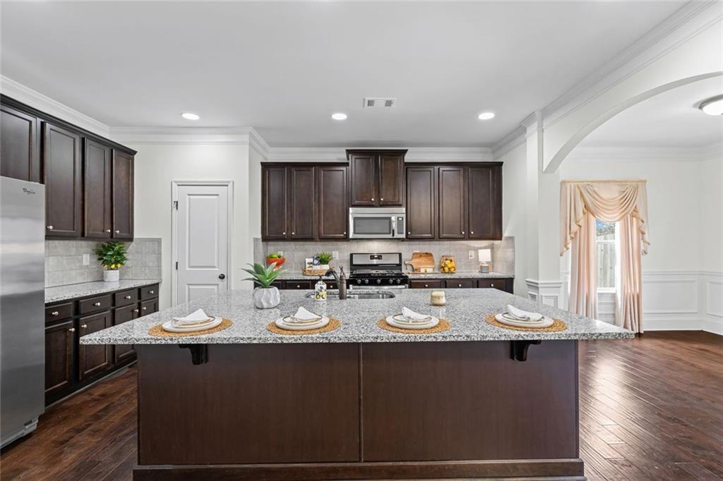 3915 Estates Path Cumming, GA 30040 - Photo 15 of 50 a kitchen with kitchen island granite countertop a sink cabinets and wooden floor