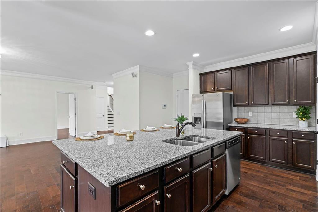 3915 Estates Path Cumming, GA 30040 - Photo 19 of 50 a kitchen with stainless steel appliances granite countertop a sink stove and cabinets