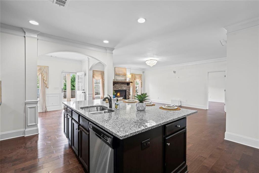 3915 Estates Path Cumming, GA 30040 - Photo 21 of 50 a kitchen with granite countertop kitchen island a sink appliances and wooden floor