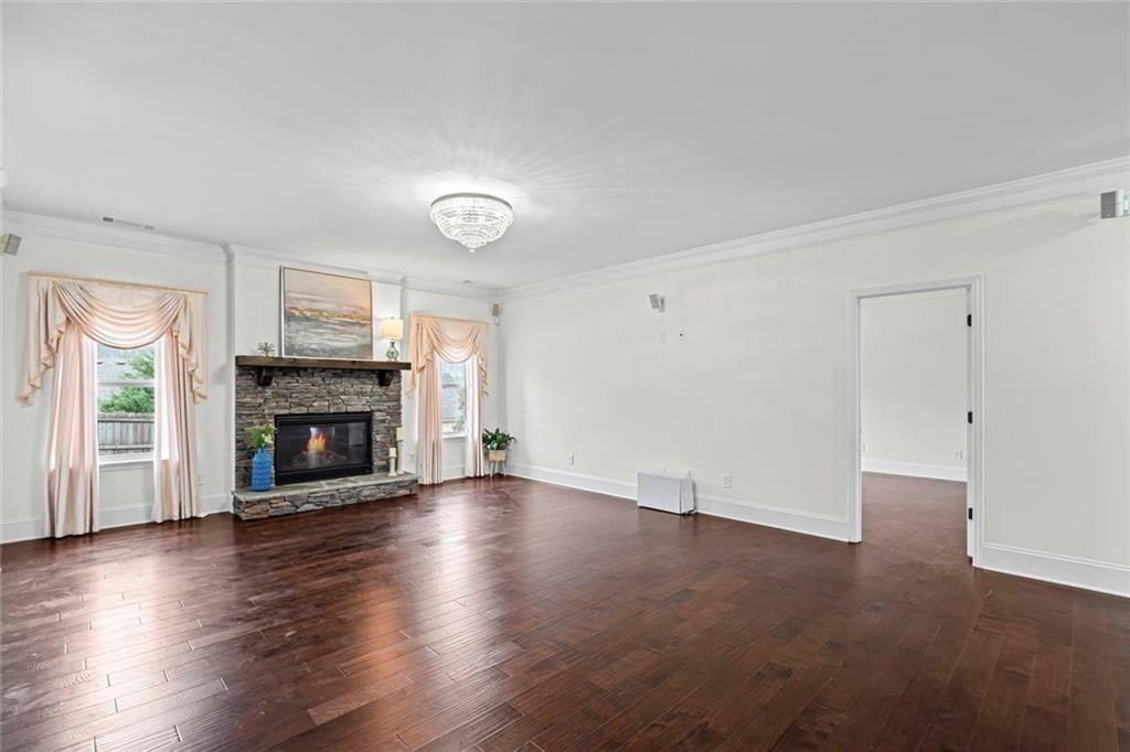 3915 Estates Path Cumming, GA 30040 - Photo 10 of 50 an empty room with wooden floor fireplace and windows