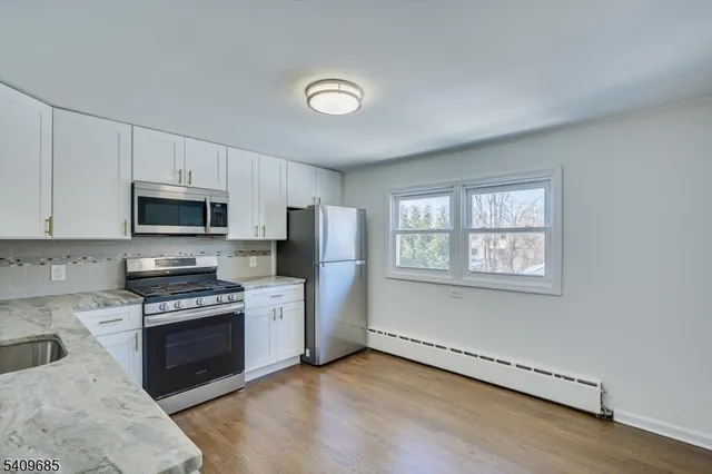 a kitchen with granite countertop stainless steel appliances a stove sink and microwave