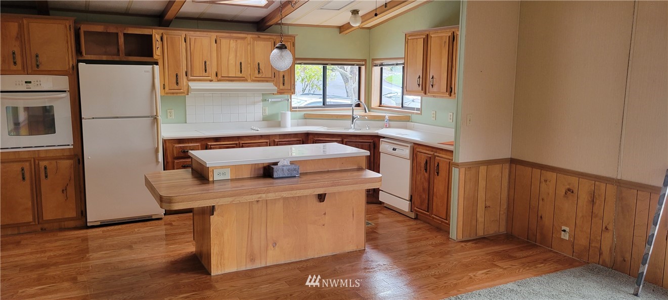 729 236th Place Southwest Bothell, WA 98021 - Photo 18 of 40 a kitchen with a sink a stove cabinets and wooden floor