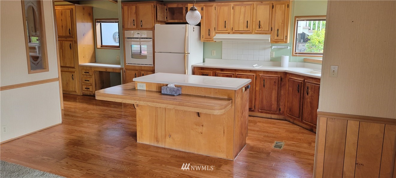729 236th Place Southwest Bothell, WA 98021 - Photo 19 of 40 a kitchen with stainless steel appliances granite countertop a sink and a stove with wooden floor