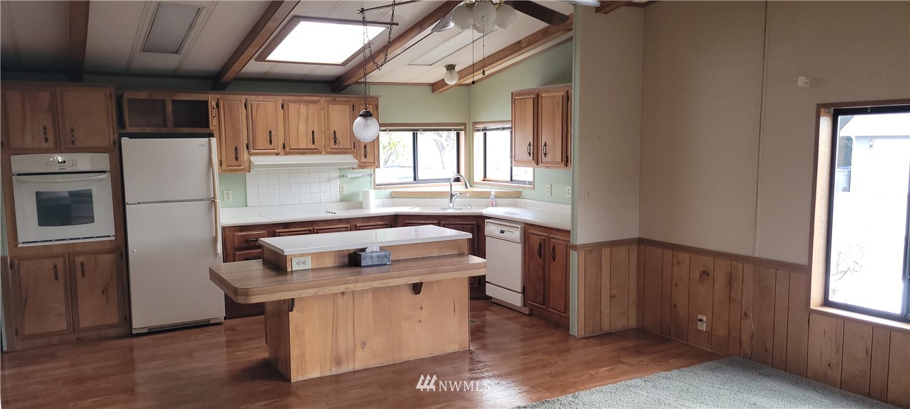 729 236th Place Southwest Bothell, WA 98021 - Photo 32 of 40 a kitchen with stainless steel appliances granite countertop a stove a sink dishwasher a refrigerator and a microwave oven with wooden floor