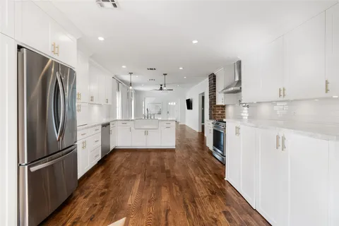 a kitchen with stainless steel appliances a refrigerator and a stove top oven