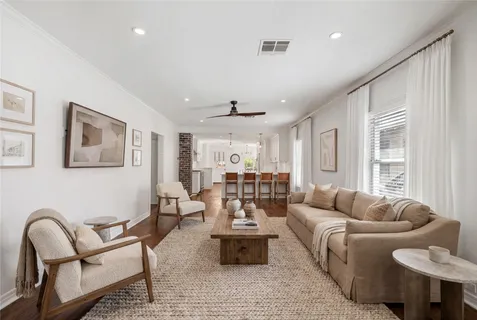 a living room with furniture and wooden floor
