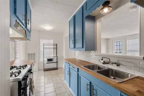 a kitchen that has a sink cabinets counter space and appliances