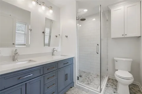 a bathroom with a sink a toilet and shower