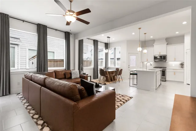 a living room with furniture and a large window with kitchen view