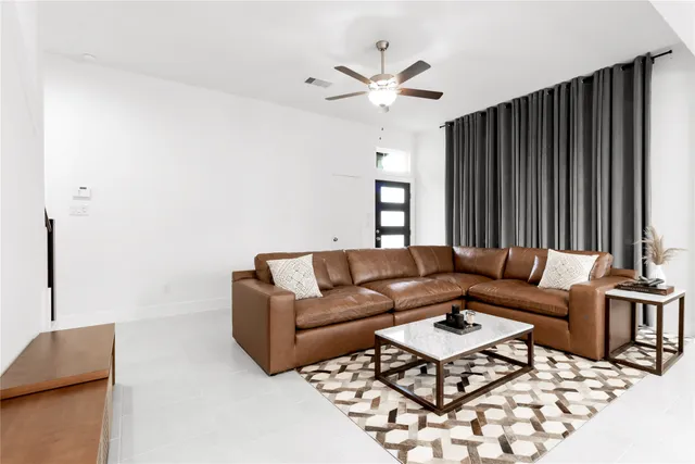a living room with furniture ceiling fan and a rug