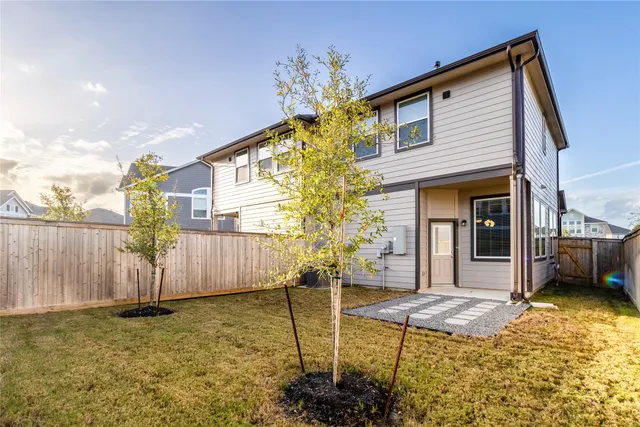 a view of a house with backyard and trees