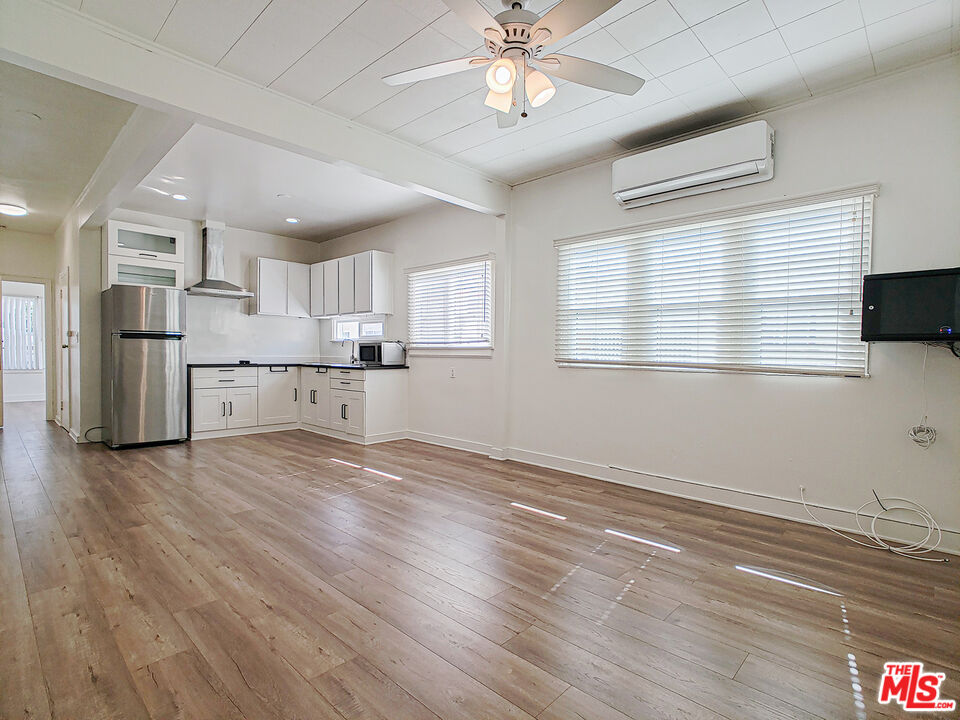 a view of a kitchen with a stove cabinets a ceiling fan and wooden floor