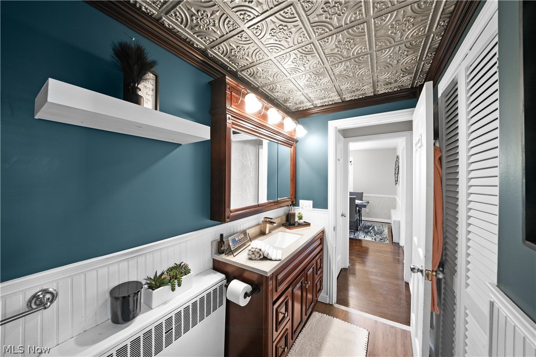 2069 State Road Northwest Warren, OH 44481 - Photo 8 of 45 Bathroom with hardwood / wood-style flooring, vanity, radiator heating unit, and ornamental molding