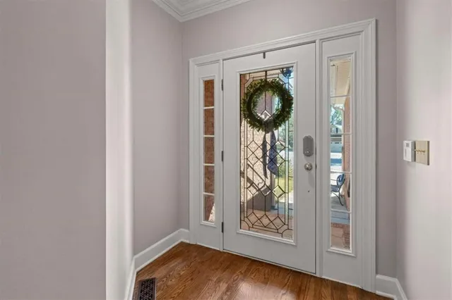 an entryway with wooden floor cabinet and a mirror