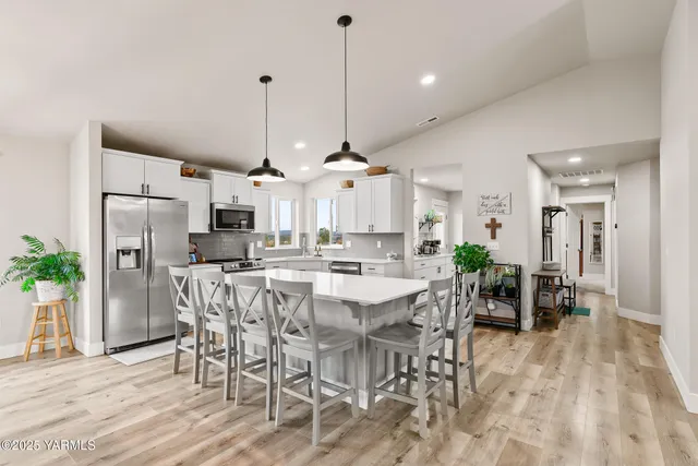 a view of a dining room and livingroom with furniture wooden floor a chandelier