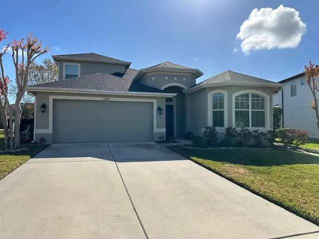a front view of a house with a yard and a garage