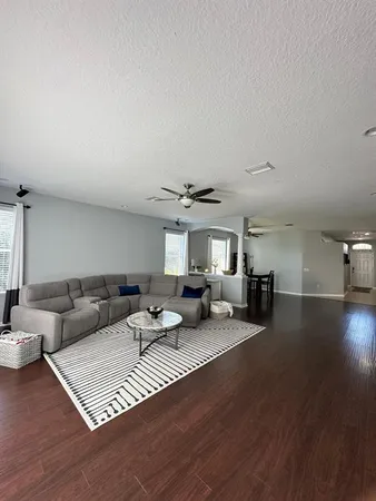 a living room with furniture and a wooden floor