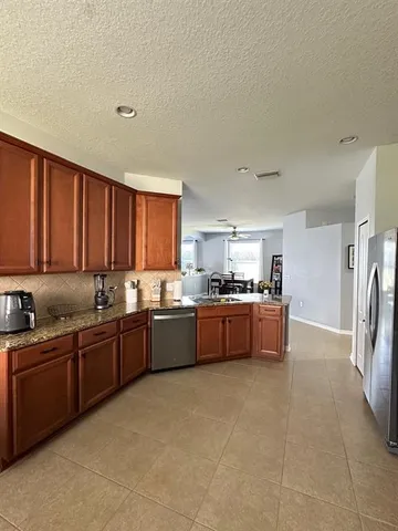 a large kitchen with a large counter top space a sink a window and stainless steel appliances