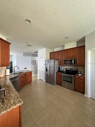 a large kitchen with stainless steel appliances lots of counter top space