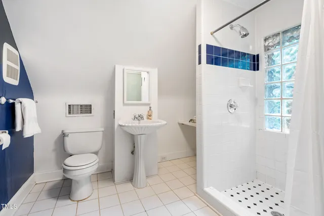 a white toilet sitting next to a bath tub