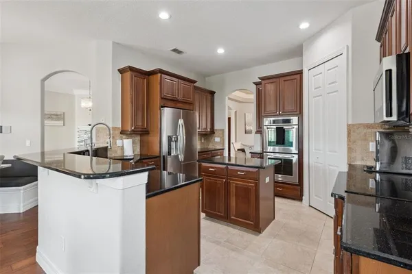 a kitchen with stainless steel appliances granite countertop a refrigerator and a stove